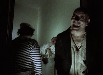 Movie still from “The Tempest” (1979), directed by Derek Jarman – A group of people standing next to each other in a room; Medium shot, Low angle