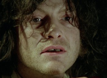 Movie still from “The Tempest” (1979), directed by Derek Jarman – A person with long hair; Close Up shot, Low angle