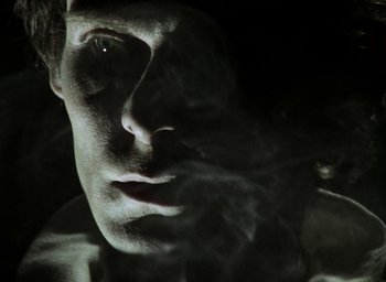 Movie still from “The Tempest” (1979), directed by Derek Jarman – A man's face with smoke coming out of his mouth; Extreme Close Up shot, Low angle