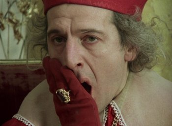 Movie still from “The Tempest” (1979), directed by Derek Jarman – A person with a hand on his mouth; Close Up shot, Over the shoulder angle
