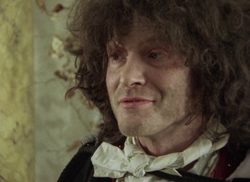 Movie still from “The Tempest” (1979), directed by Derek Jarman – A person wearing a bow tie; Close Up shot, Over the shoulder angle