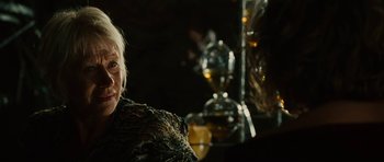 Movie still from “The Tempest” (2010), directed by Julie Taymor – An older woman sitting in front of a glass vase; Close Up shot, Over the shoulder angle