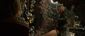 Movie still from “The Tempest” (2010), directed by Julie Taymor – A woman holding a bow in a cave; Medium shot, Over the shoulder angle