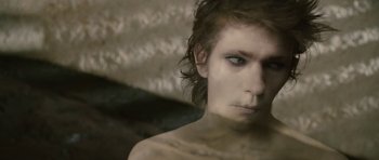 Movie still from “The Tempest” (2010), directed by Julie Taymor – A man with a very long hair and a very dark eye makeup; Close Up shot, High angle