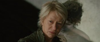 Movie still from “The Tempest” (2010), directed by Julie Taymor – An older woman is looking at the camera; Close Up shot, Low angle