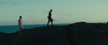 Movie still from “The Tempest” (2010), directed by Julie Taymor – A man walking on top of a rock near the ocean; Wide shot, Low angle