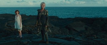 Movie still from “The Tempest” (2010), directed by Julie Taymor – An older woman standing on top of a rocky cliff; Medium shot, Low angle