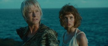 Movie still from “The Tempest” (2010), directed by Julie Taymor – Two women standing next to each other near the ocean; Close Up shot, Low angle