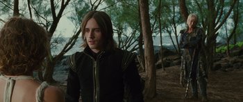 Movie still from “The Tempest” (2010), directed by Julie Taymor – A man in a black jacket standing next to a tree; Medium shot, Over the shoulder angle