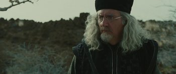 Movie still from “The Tempest” (2010), directed by Julie Taymor – An old man with long white hair and glasses; Close Up shot, Over the shoulder angle