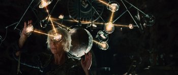 Movie still from “The Tempest” (2010), directed by Julie Taymor – A woman holding a mirror in front of a chandelier; Close Up shot, Overhead angle