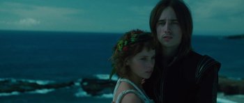 Movie still from “The Tempest” (2010), directed by Julie Taymor – A man and a woman standing next to each other near the ocean; Close Up shot, High angle