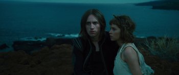 Movie still from “The Tempest” (2010), directed by Julie Taymor – A man and a woman standing next to each other on the beach; Medium shot, High angle