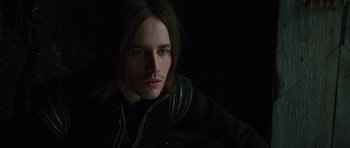 Movie still from “The Tempest” (2010), directed by Julie Taymor – A man with long brown hair wearing a black jacket; Close Up shot, Low angle
