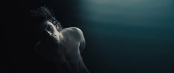 Movie still from “The Tempest” (2010), directed by Julie Taymor – A man with no shirt is running in the dark; Close Up shot, Low angle