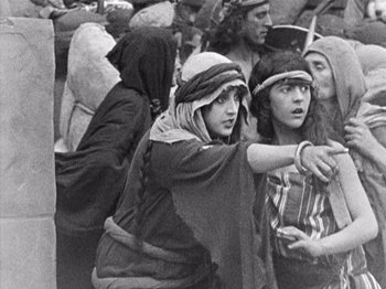 Movie still from “The Ten Commandments” (1923), directed by Cecil B. DeMille – A group of people standing around each other in a crowd; Medium shot, High angle