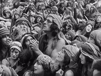 Movie still from “The Ten Commandments” (1923), directed by Cecil B. DeMille – An old photo of a group of people gathered together; Medium shot, High angle