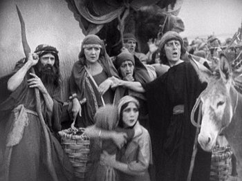 Movie still from “The Ten Commandments” (1923), directed by Cecil B. DeMille – A black and white photo of a group of people; Wide shot, High angle