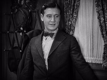 Movie still from “The Ten Commandments” (1923), directed by Cecil B. DeMille – A man wearing a suit and bow tie; Medium shot, High angle