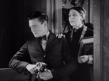 Movie still from “The Ten Commandments” (1923), directed by Cecil B. DeMille – An older woman holding a young man's arm; Medium shot, High angle