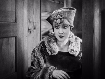 Movie still from “The Ten Commandments” (1923), directed by Cecil B. DeMille – An old photo of a woman wearing a hat; Medium shot, High angle