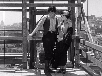 Movie still from “The Ten Commandments” (1923), directed by Cecil B. DeMille – A man and a woman standing next to each other on a bridge; Medium shot, Low angle