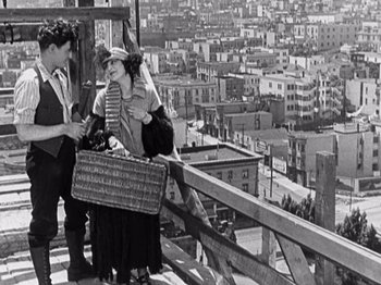 Movie still from “The Ten Commandments” (1923), directed by Cecil B. DeMille – A man and a woman standing on a wooden platform; Wide shot, High angle