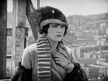 Movie still from “The Ten Commandments” (1923), directed by Cecil B. DeMille – An old photo of a woman with a gun in her hand; Close Up shot, Low angle