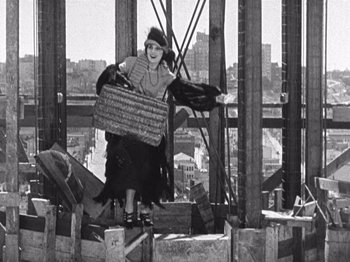Movie still from “The Ten Commandments” (1923), directed by Cecil B. DeMille – An old photo of a woman holding a basket on top of a building; Wide shot, Low angle