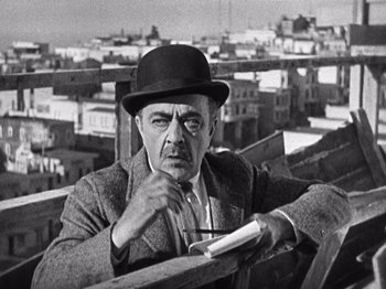 Movie still from “The Ten Commandments” (1923), directed by Cecil B. DeMille – An older man wearing a hat and holding a book; Medium shot, Low angle