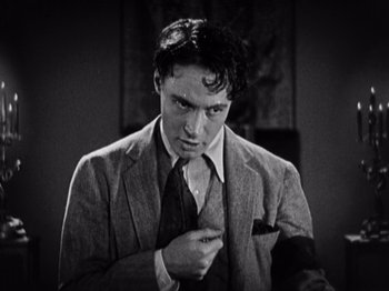 Movie still from “The Ten Commandments” (1923), directed by Cecil B. DeMille – A man wearing a suit and tie holding a tie; Close Up shot, High angle