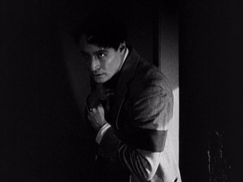 Movie still from “The Ten Commandments” (1923), directed by Cecil B. DeMille – A black and white photo of a man in a suit; Medium shot, High angle