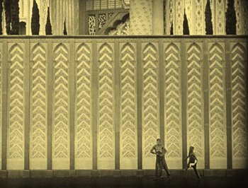 Movie still from “The Thief of Bagdad” (1924), directed by Raoul Walsh – Two men are standing in front of a wall; Extreme Wide shot, Low angle
