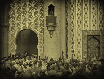 Movie still from “The Thief of Bagdad” (1924), directed by Raoul Walsh – A crowd of people standing in front of a building; Extreme Wide shot, High angle