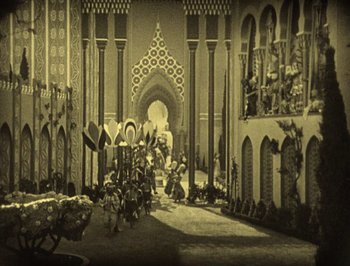 Movie still from “The Thief of Bagdad” (1924), directed by Raoul Walsh – An old photograph of people walking through a courtyard; Extreme Wide shot, High angle