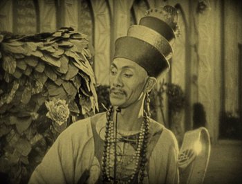 Movie still from “The Thief of Bagdad” (1924), directed by Raoul Walsh – An old photograph of a man wearing a turban; Medium shot, High angle