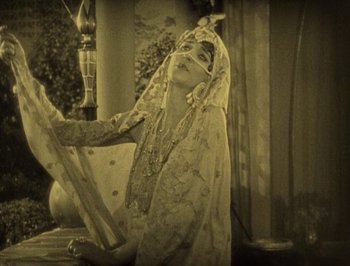Movie still from “The Thief of Bagdad” (1924), directed by Raoul Walsh – An old photo of a woman in a traditional dress; Medium shot, High angle