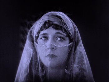 Movie still from “The Thief of Bagdad” (1924), directed by Raoul Walsh – A woman with a head covering looking up at the sky; Close Up shot, Low angle