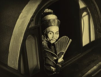 Movie still from “The Thief of Bagdad” (1924), directed by Raoul Walsh – An old photo of a person holding a fan; Medium shot, Low angle