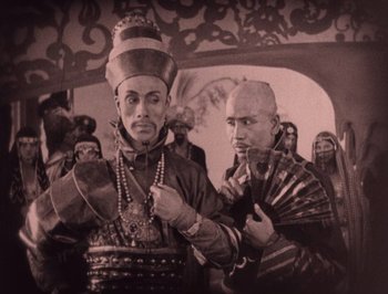 Movie still from “The Thief of Bagdad” (1924), directed by Raoul Walsh – Two men are dressed up and posing for a picture; Medium shot, Low angle