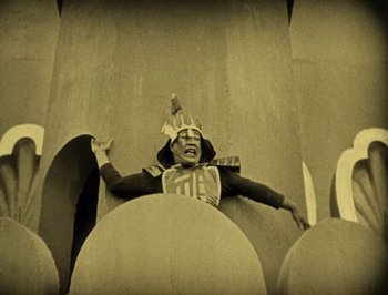 Movie still from “The Thief of Bagdad” (1924), directed by Raoul Walsh – A man in a costume is standing in a wall; Wide shot, Low angle