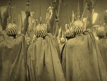 Movie still from “The Thief of Bagdad” (1924), directed by Raoul Walsh – A group of people dressed in costumes and holding swords; Medium shot, High angle