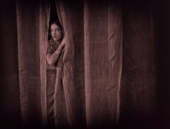 Movie still from “The Thief of Bagdad” (1924), directed by Raoul Walsh – A woman standing in front of a curtain; Wide shot, Low angle