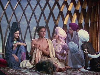 Movie still from “The Thief of Bagdad” (1940), directed by Alexander Korda – A group of people sitting on the ground with a dog; Wide shot, Low angle
