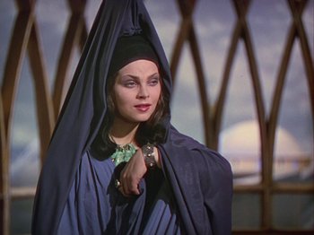 Movie still from “The Thief of Bagdad” (1940), directed by Alexander Korda – A woman wearing a black headdress and a blue robe; Medium shot, Low angle