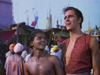 Movie still from “The Thief of Bagdad” (1940), directed by Alexander Korda – A man standing next to a shirtless man in front of a crowd of onlookers; Medium shot, Low angle