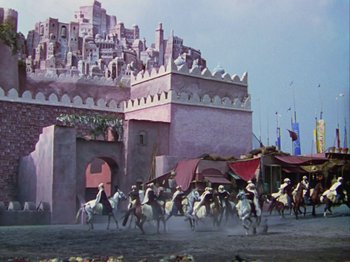 Movie still from “The Thief of Bagdad” (1940), directed by Alexander Korda – A group of people riding horses in front of a building; Extreme Wide shot, Low angle