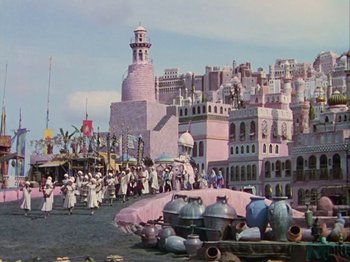 Movie still from “The Thief of Bagdad” (1940), directed by Alexander Korda – A group of people standing around a pink building; Extreme Wide shot, High angle