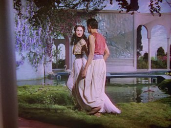 Movie still from “The Thief of Bagdad” (1940), directed by Alexander Korda – A woman and a young man are standing next to each other; Wide shot, Low angle
