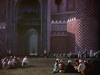 Movie still from “The Thief of Bagdad” (1940), directed by Alexander Korda – A group of people sitting in front of a building; Extreme Wide shot, High angle